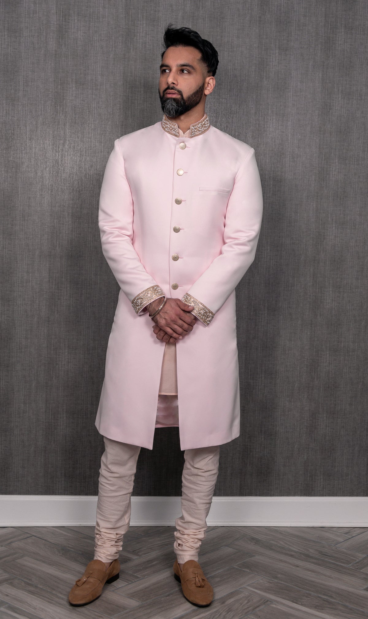 Front-facing view of PARAM light pink sherwani jacket with pearl cuffs and collar in front of simple gray background