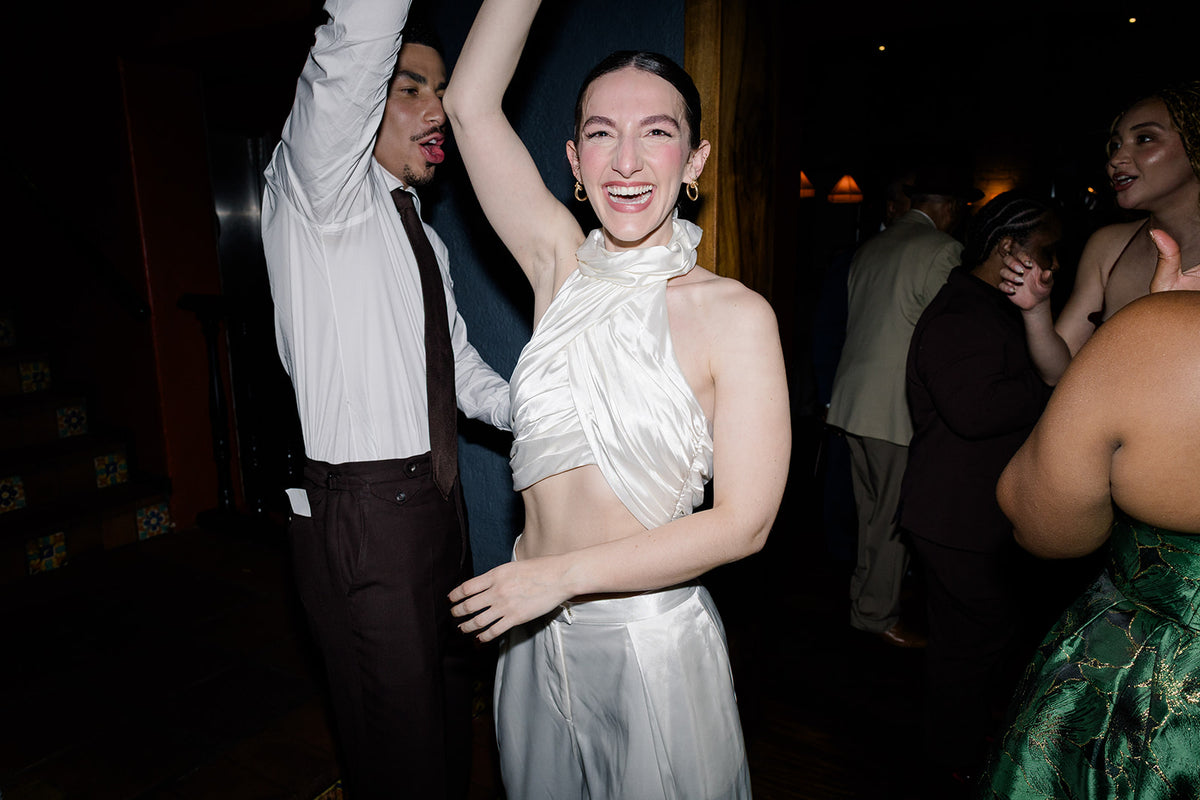 All smiles with Harleen Kaur Bride Gracie in a custom silky ivory halter top for her wedding reception at Republique in LA