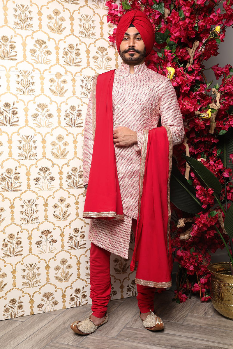 Front view- Man holding red silk groom's stole with gold trim in front of a gold background