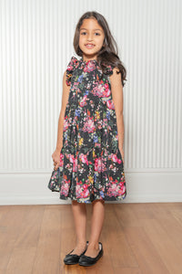 Satya wearing the Paloma Black Tiered Dress with a vibrant floral pattern throughout - Front View - Harleen Kaur