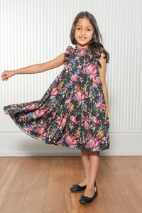 Satya wearing a black tiered dress with vibrant florals - Front View - Harleen Kaur