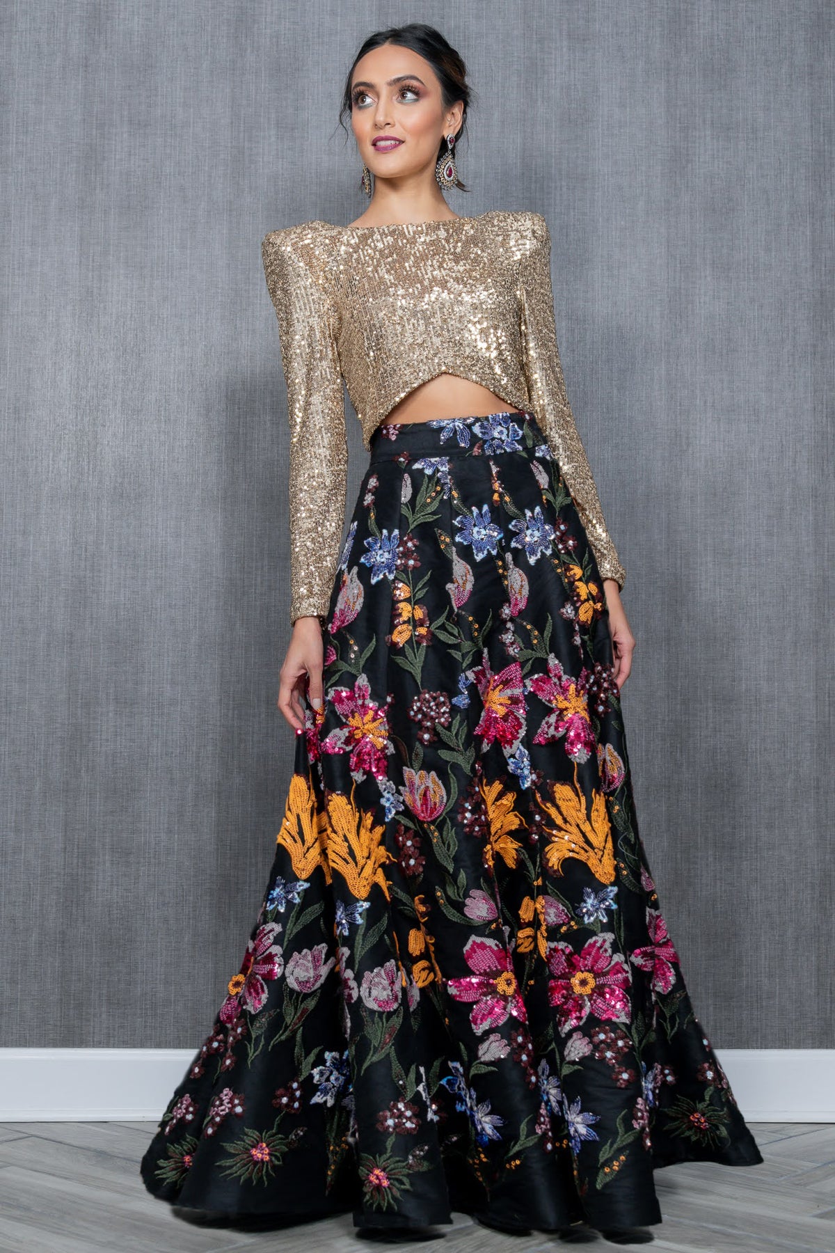 Model in the High Waisted Black Pallavi Lehenga Skirt with Vibrant Floral Details styled with the Long Sleeve Gold Sequin Naina Top